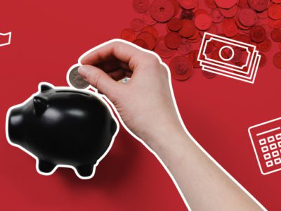 person dropping a coin in a piggy bank